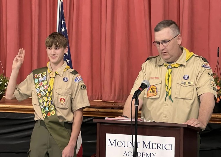 Nathan and Lee: Nathan receives the Eagle Scout Charge from Lee Pettengill who is the Chartered Organization Representative for Troop 479 and served as Master of Ceremonies for the Eagle Court of Honor Ceremony. Nathan: Nathan Choate, Eagle Scout, makes the Scout Sign during his Eagle Scout Ceremony Stephanie pins Nathan: Stephanie Drake Choate pins the Eagle Scout medal onto her son's uniform. "It was so special to have it at Mount Merici Academy. We are so proud of you, Nathan," she said. Joe and Nathan: Joe Doore of the Town of Albion spoke about why Nathan received the Spirit of America Award from the Town of Albion earlier this year. Elijay Parish Lovejoy was born in Albion in 1802 and was an American newspaper editor who was killed by a mob for his firm, published positions denouncing slavery in 1837. Nathan's Eagle Scout Project restored the marker in Albion commemorating Lovejoy.